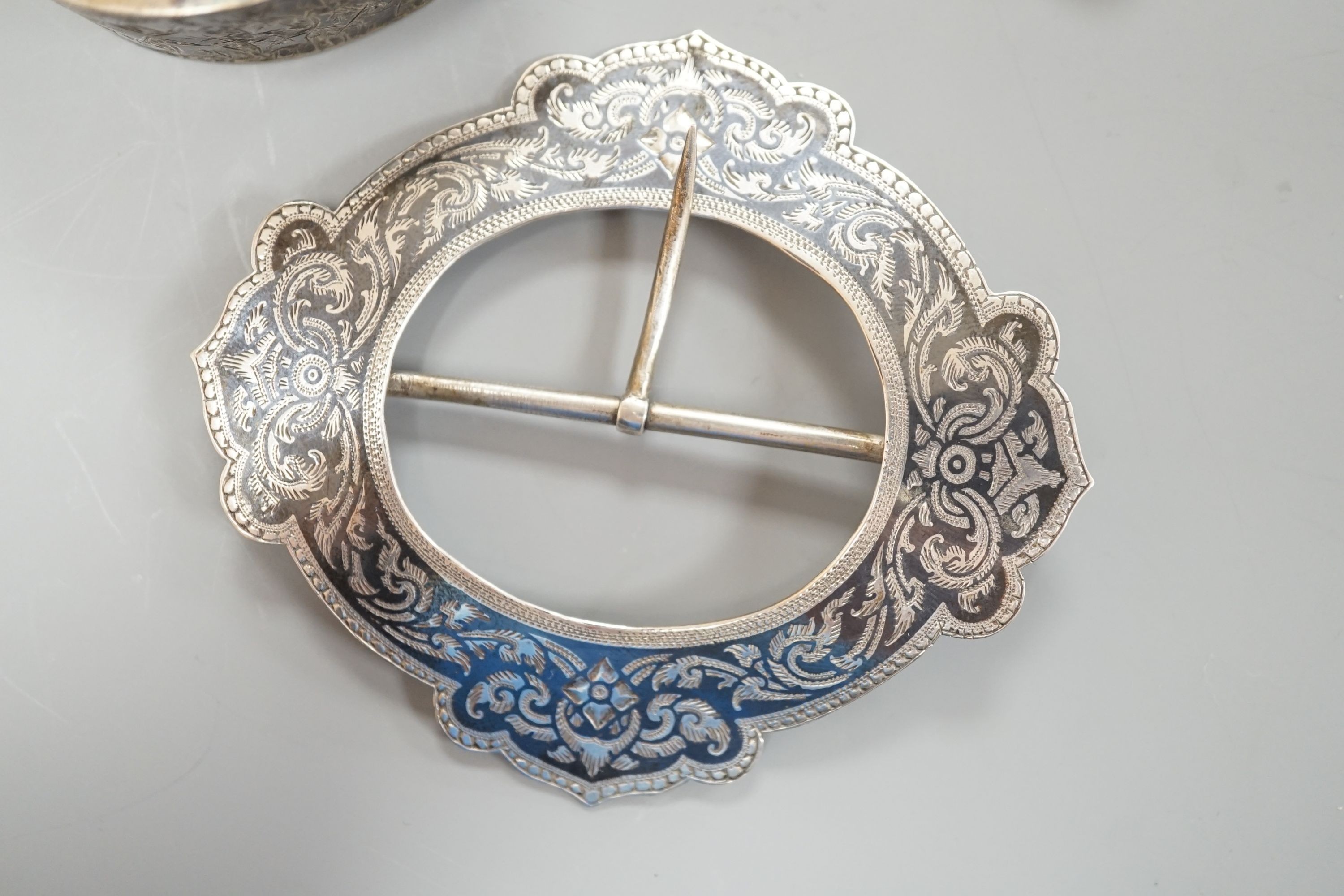 A late Victorian engraved silver hinged bangle, a white metal and niello buckle and a pair of mid 20th century Norwegian gilt 925 and enamel leaf ear clips by Hans Myhre.